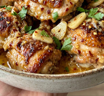 Morceaux de poulet laqués à la sauce ail et piment dans un wok, servis avec du riz blanc