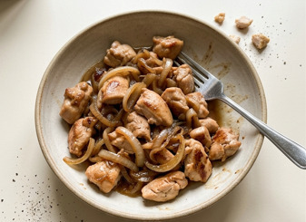 Sauté de poulet aux oignons dorés dans un wok, sauce brillante et légumes colorés